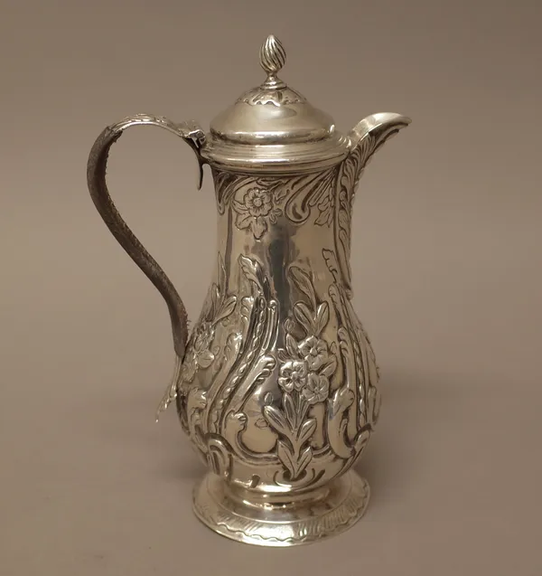 A George III silver hot water jug, of baluster form, the body with floral and foliate scrolling decoration, raised on a circular foot, by  John Langla