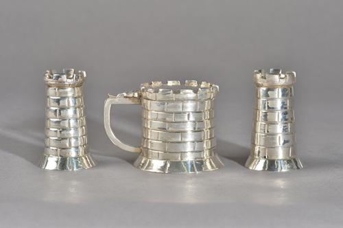A plated novelty three piece condiment set, comprising; a mustard pot and a pair of pepperettes, each designed as a castle, the mustard pot with a blu