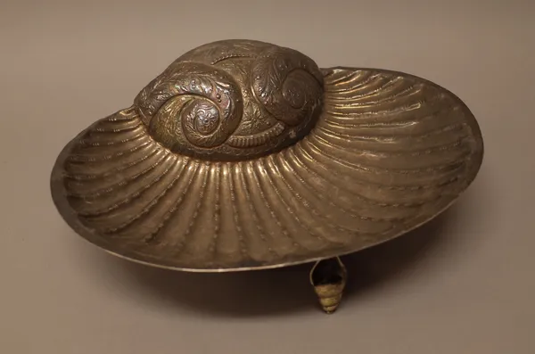 A foreign dish, of scallop shell form, decorated with floral and foliate scrolls and raised on three snail shaped feet, width 36.5cm.  1357