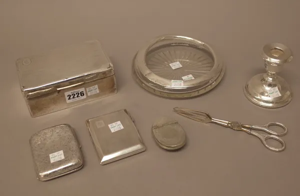 Silver and silver mounted wares, comprising; a rectangular table cigarette box, a circular glass ashtray, a small candle stick (loaded) and two cigare