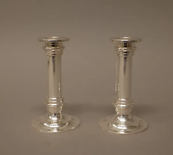 A pair of small table candlesticks, each of turned form, raised on a circular base, 12.5cm high, detailed 925 Jezler, combined weight 604 gms.