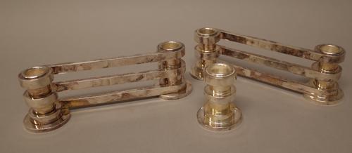 A pair of French plated twin light candle stands, each of triple bar twist over form, detailed Puiforcat, Paris, 7cm high and one single candle stand,