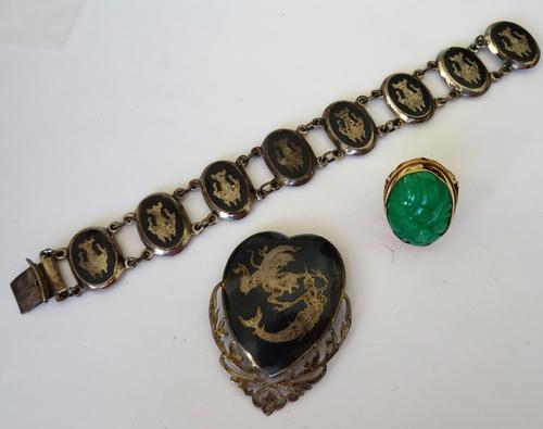 A 9ct gold mounted chrysoprase single stone ring, with carved and pierced decoration, a Siamese silver and niello decorated brooch and a Siamese silve