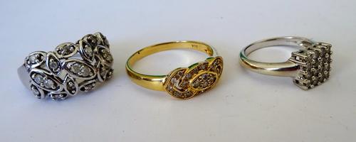 A 9ct white gold and diamond ring in a pierced abstract design (one diamond lacking), a 9ct white gold and diamond set sixteen stone square cluster ri