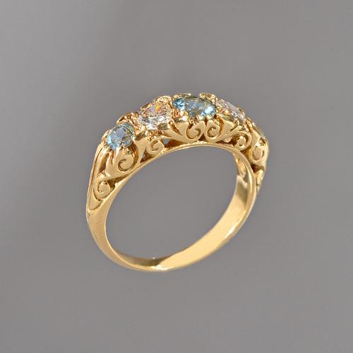 An 18ct gold, aquamarine and diamond five stone ring, mounted with three circular cut aquamarines, alterniating with two circular cut diamonds, the mo