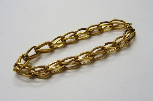 A gold bracelet, designed as a series of textured links, alternating with plain links, detailed 750, on a boltring clasp, detailed 750, gross weight 1