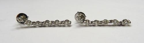A pair of 18ct white gold and diamond earrings, each mounted with a row of six circular cut diamonds, the backs with post and butterfly clip fittings.