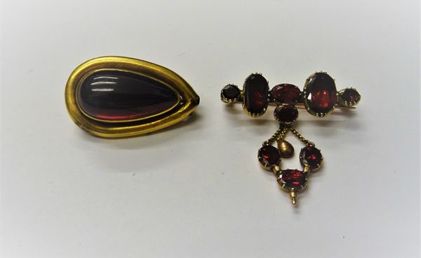 A Victorian gold and carbuncle garnet set brooch, of drop shaped form, mounted with a foil backed carbuncle garnet, the back glazed with a hairlocket