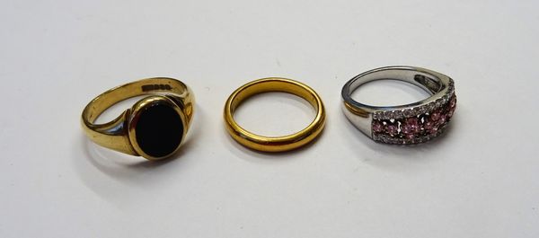 A 22ct gold plain wedding ring, London 1937, weight 5 gms, a 9ct gold and black onxy oval signet ring and a pink and colourless gem set dress ring, de