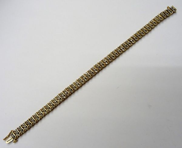 A 9ct gold and diamond bracelet, in a serpentine link design, mounted with rows of three cicrcular cut diamonds, on a snap clasp, length 19.4cm, gross