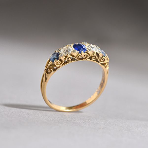 A gold, sapphire and diamond set half hoop ring, mounted with three cushion shaped sapphires, alternating with two cushion shaped diamonds and with fo