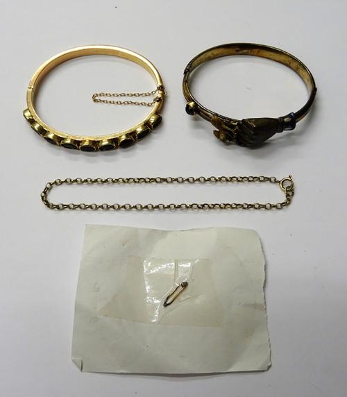 A gold and amethyst set oval hinged bangle, the front collet set with a row of nine oval cut amethysts, on a snap clasp, a garnet set and enamelled ov