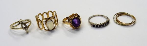 A 9ct gold ring, mounted with an oval moonstone, the mount in a pierced oval openwork design, a gold ring, mounted with an oval cut amethyst, in a sty