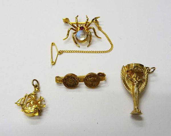 A gold, ruby and moonstone brooch, designed as a spider, a 9ct gold pendant, designed as The World Cup, detailed England 1966, a 9ct gold charm, desig