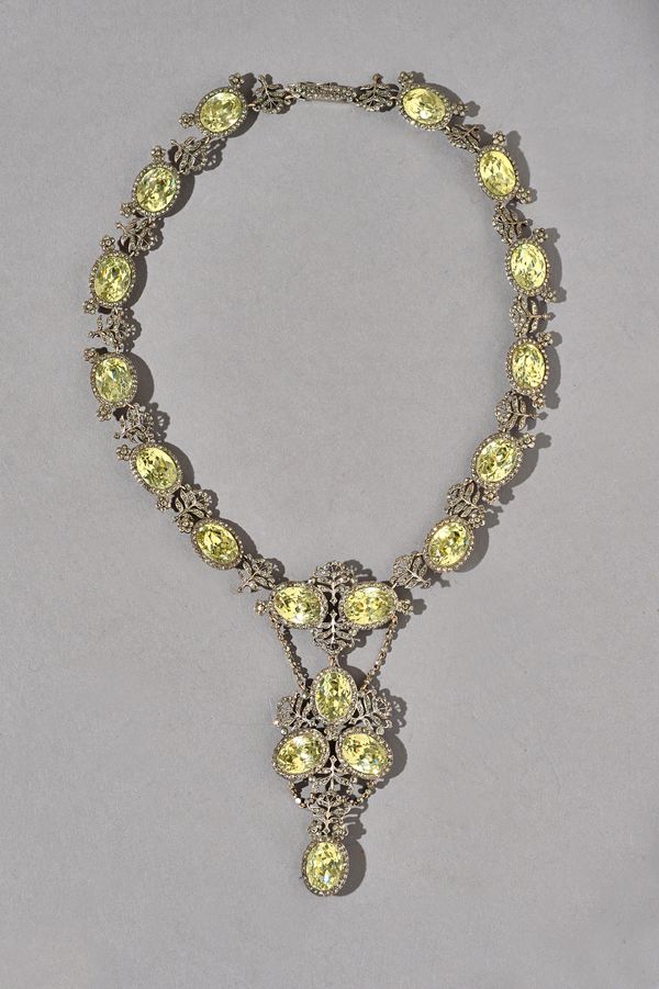 A silver mounted foil backed yellow paste and marcasite set necklace, mounted with a row of foil backed oval cut yellow pastes alternating with marcas