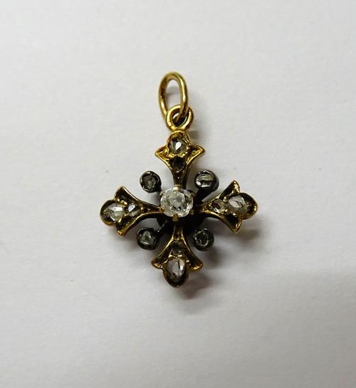 A diamond set small pendant cross, mounted with the principal cushion shaped diamond to the centre and otherwise set with rose cut diamonds, width 1.2