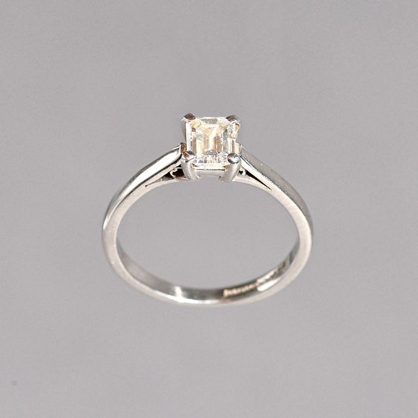 A platinum and diamond single stone ring, claw set with a cut cornered rectangular emerald cut diamond, ring size I, the diamond weighs approx 0.52 ct