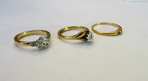 A 9ct gold and diamond single stone ring, mounted with a circular cut diamond in a twist design, a gold and diamond set three stone ring and a 9ct gol