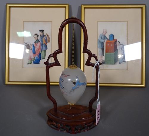 A 20th century Chinese Peking glass hanging ornament of ovoid form, decorated with birds, within a hardwood arch top stand, 19cm high and two rice pap
