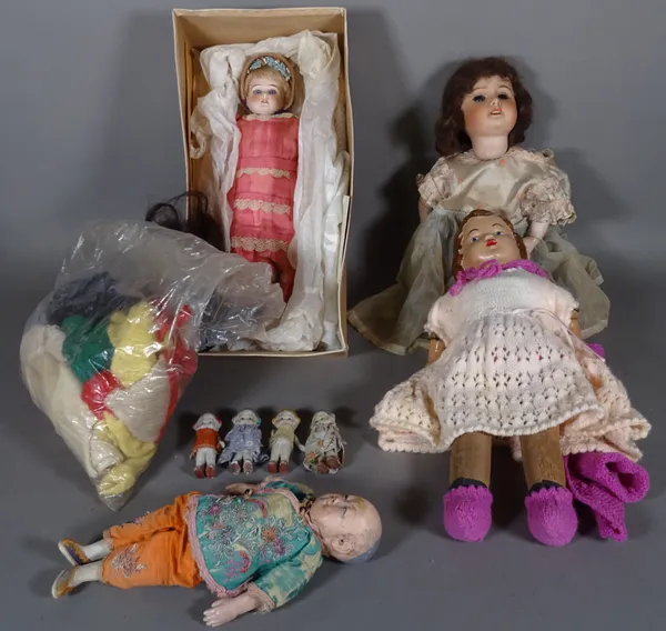 A group of eight early 20th century dolls and a quantity of doll's clothing, (8).  CAB