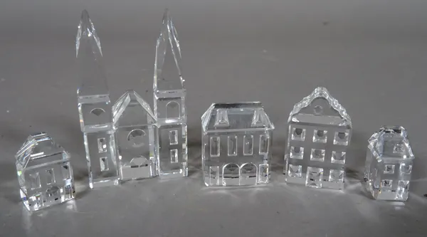 Swarovski; a group of four miniature glass houses and a miniature glass church, (5).  CAB