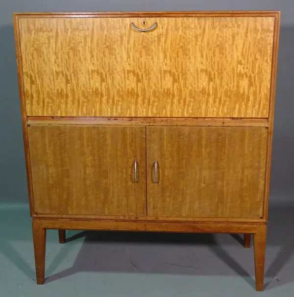 Gordon Russell; a 20th century teak side cabinet with fall front over two door cupboard, on tapering supports, 101cm wide x 119cm high.  J10
