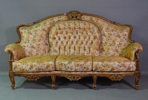 A 20th century hardwood framed three seater sofa with roll-over arms, button back gold floral upholstery on scroll supports, 200cm wide.   D5