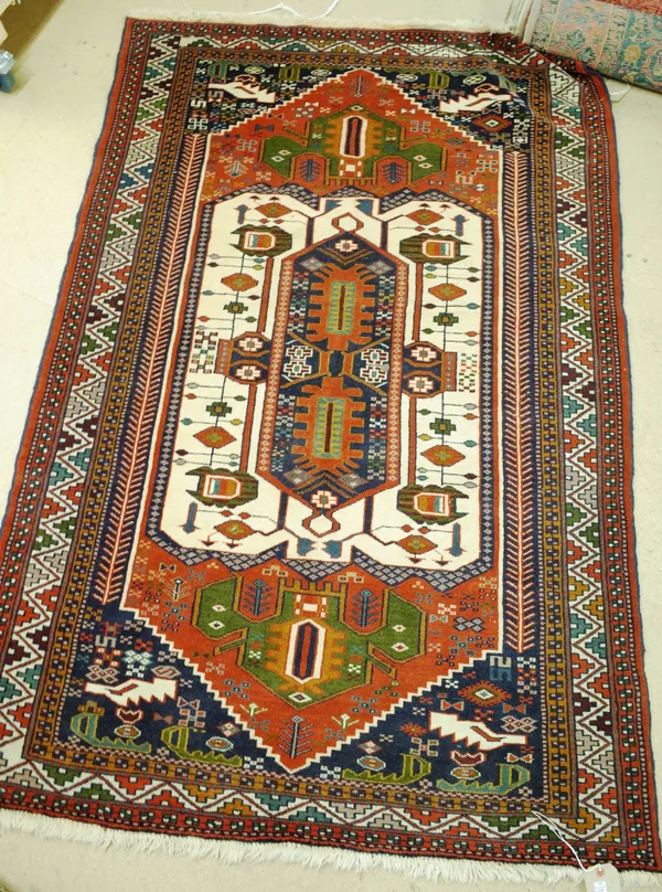 A late 20th century decorative rug with white red and blue stepped medallion within blue spandrels, 179cm x 121cm.  BAY 1 4851