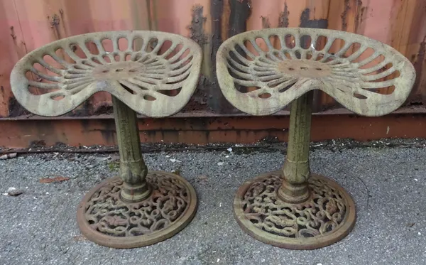 A pair of early 20th century cast iron stools previously tractor seats, 45cm wide x 49cm high (2).  OUT