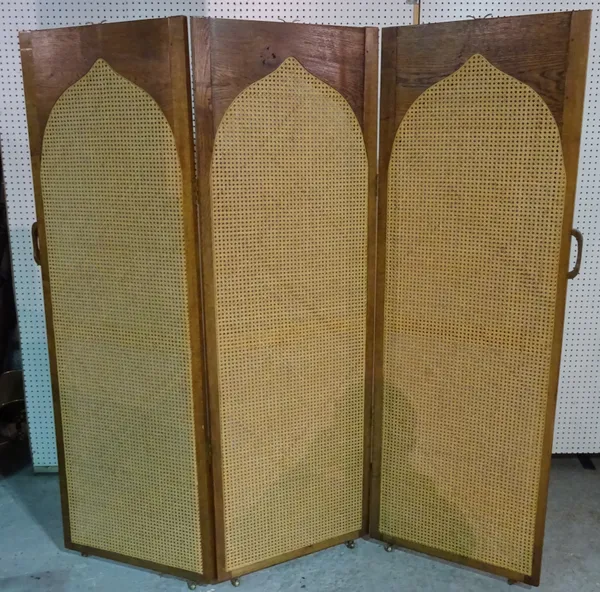 An early 20th century oak framed draught screen with arch top and canework panels, 183cm wide x 181cm high.  M5