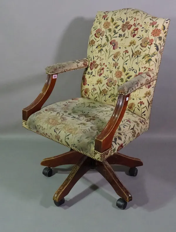 A 20th century mahogany framed hump back office open armchair with floral upholstery.   BAY 1