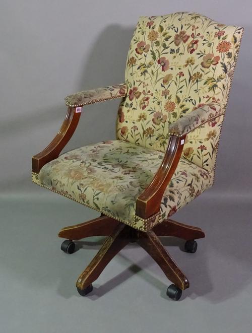 A 20th century mahogany framed hump back office open armchair with floral upholstery.   BAY 1