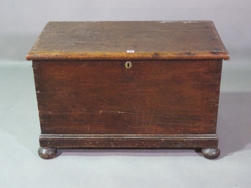 An early 20th century stained pine lift top trunk on bun feet, 88cm wide x 54cm high.   D7