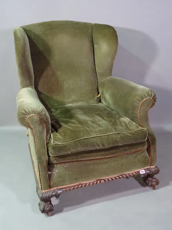 A Victorian mahogany framed wingback armchair on ball and claw feet.   C7