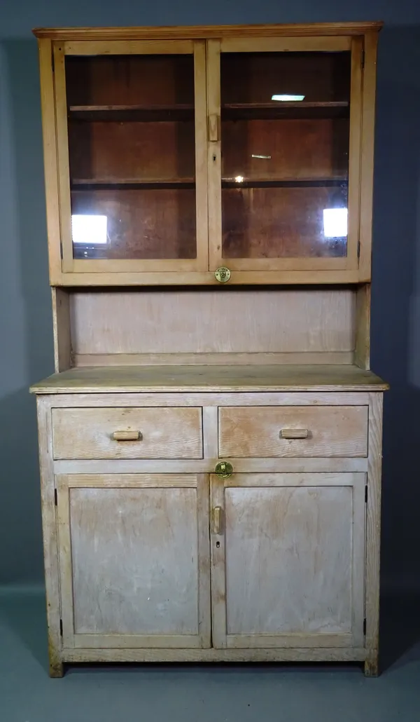 A 20th century pitch pine kitchen dresser with two door glazed top section over two drawers and cupboard base, 107cm wide x 180cm high.   M6