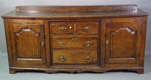 An 18th century and later oak three door dresser base on bracket feet, 195cm wide x 92cm high.   E7