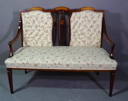 An Edwardian mahogany and marquetry inlaid two seater sofa with button back upholstery on tapering supports, 125cm wide.   F5