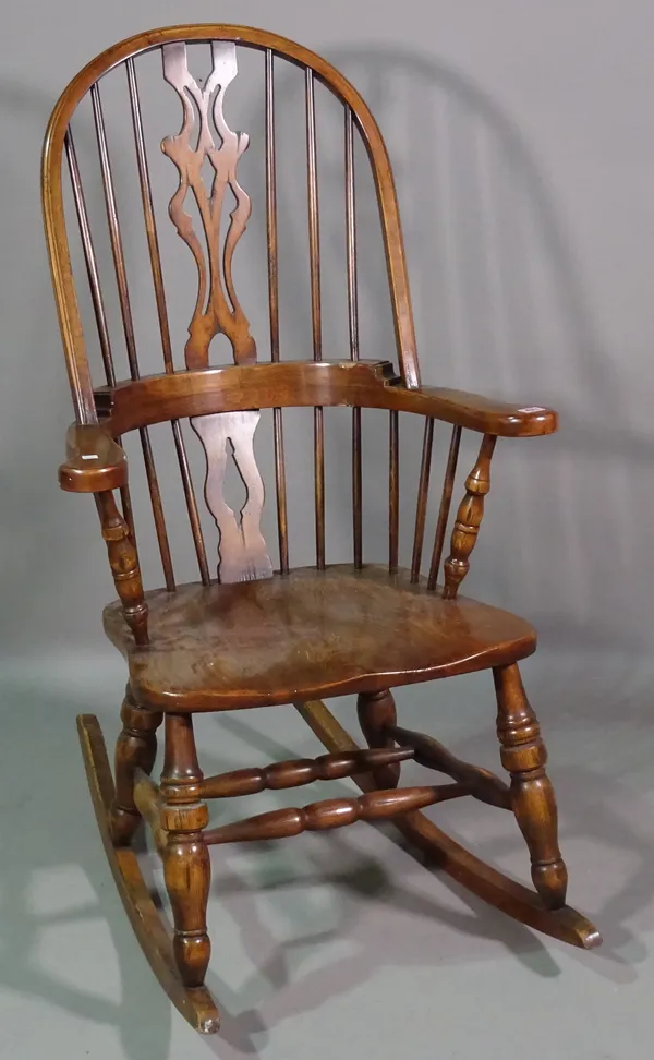 A 20th century ash and elm spindle back rocking open armchair.  K8
