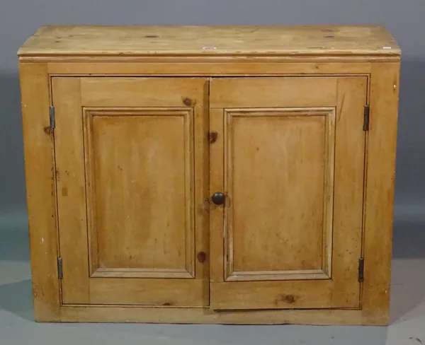 An early 20th century pine side cupboard with panelled doors, 88cm wide x 69cm high.  I7