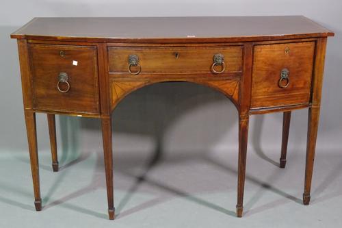A late George III inlaid mahogany bowfront sideboard, with three frieze drawers, on tapering square supports, 140cm wide x 87cm high x 64cm deep.  BAY