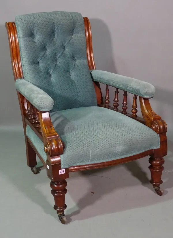 A Victorian mahogany framed low armchair with button back upholstery on ring turned supports.   I5