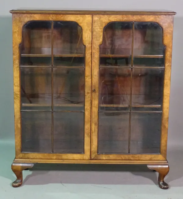 A mid-20th century figured walnut display cabinet with arch panel doors on pad feet, 94cm wide x 109cm high.   K7