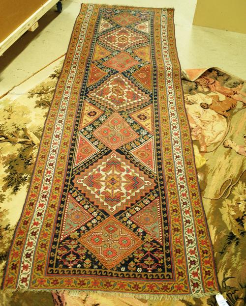 A Persian tribal runner with seven medallions within polychrome borders, 98cm x 258cm and a machine tapestry after a design by Watteau, (2).     J7
