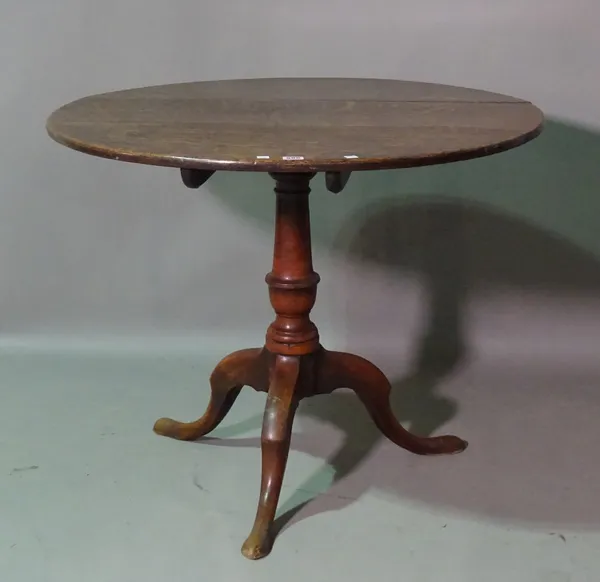 A George III oak circular tilt top tripod table, on outswept supports, 87cm wide x 70cm high.  H10