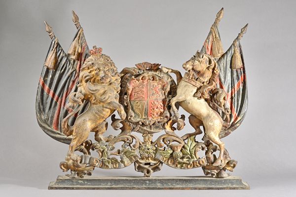 A polychrome painted cast iron plaque probably The Royal Warrant coat of arms, (a.f.), on a later plinth, 68cm wide.  Illustrated