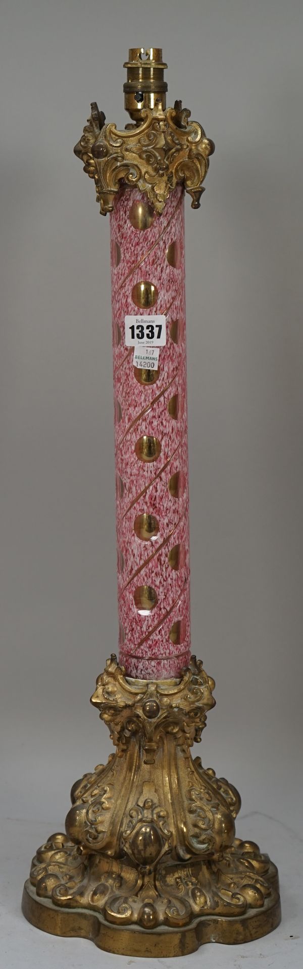 A Victorian cased glass and gilt metal mounted table lamp of column form, the circular mottled pink body with thumbnail cut decoration, 60cm high.