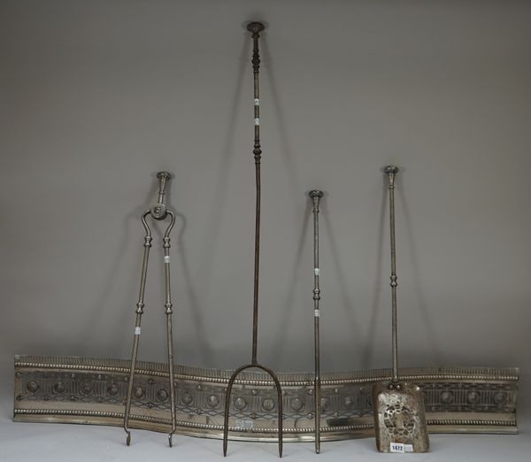 A set of three Victorian steel fire irons, with knopped shafts and a matching log fork, the later 104cm and a serpentine fender, (5).