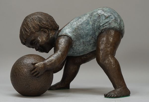 Owen; a modern patinated bronze of a toddler playing with a ball, signed 'Owen 3/7' with Morris Singer foundry stamp, 18cm high. DDS