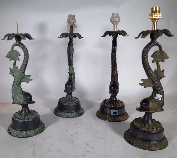 A group of four 20th century metal table lamps, the column formed as dolphins on circular plinth bases, 43cm high.