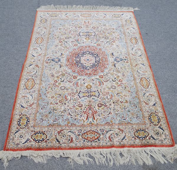 A Qum silk rug, the ivory field with a madder roundel, pale indigo spandrels, all with delicate floral sprays, a beige leaf and cartouche border, 188c